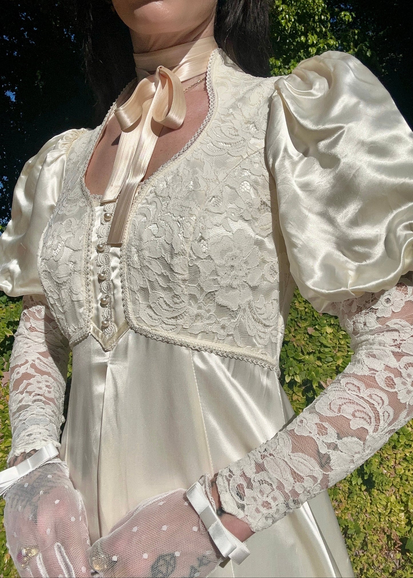 Person wearing a vintage-style dress with lace details outdoors.