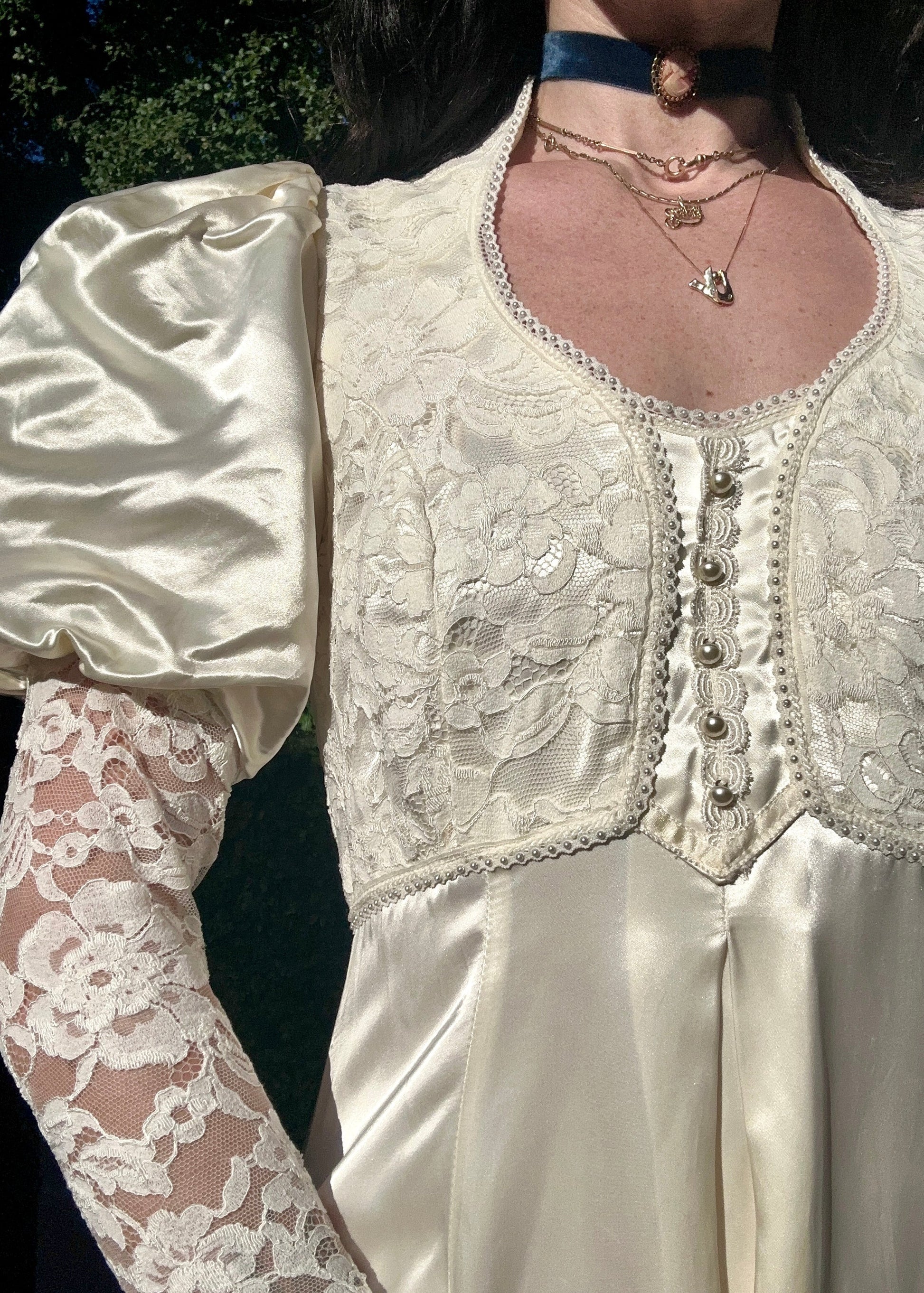 Close-up of a person wearing a white lace dress with puffed sleeves.