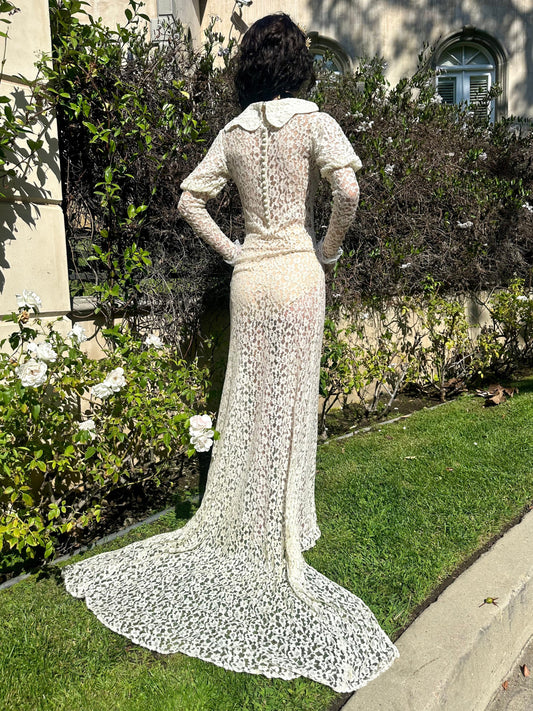 Person wearing a white lace dress standing in a garden.