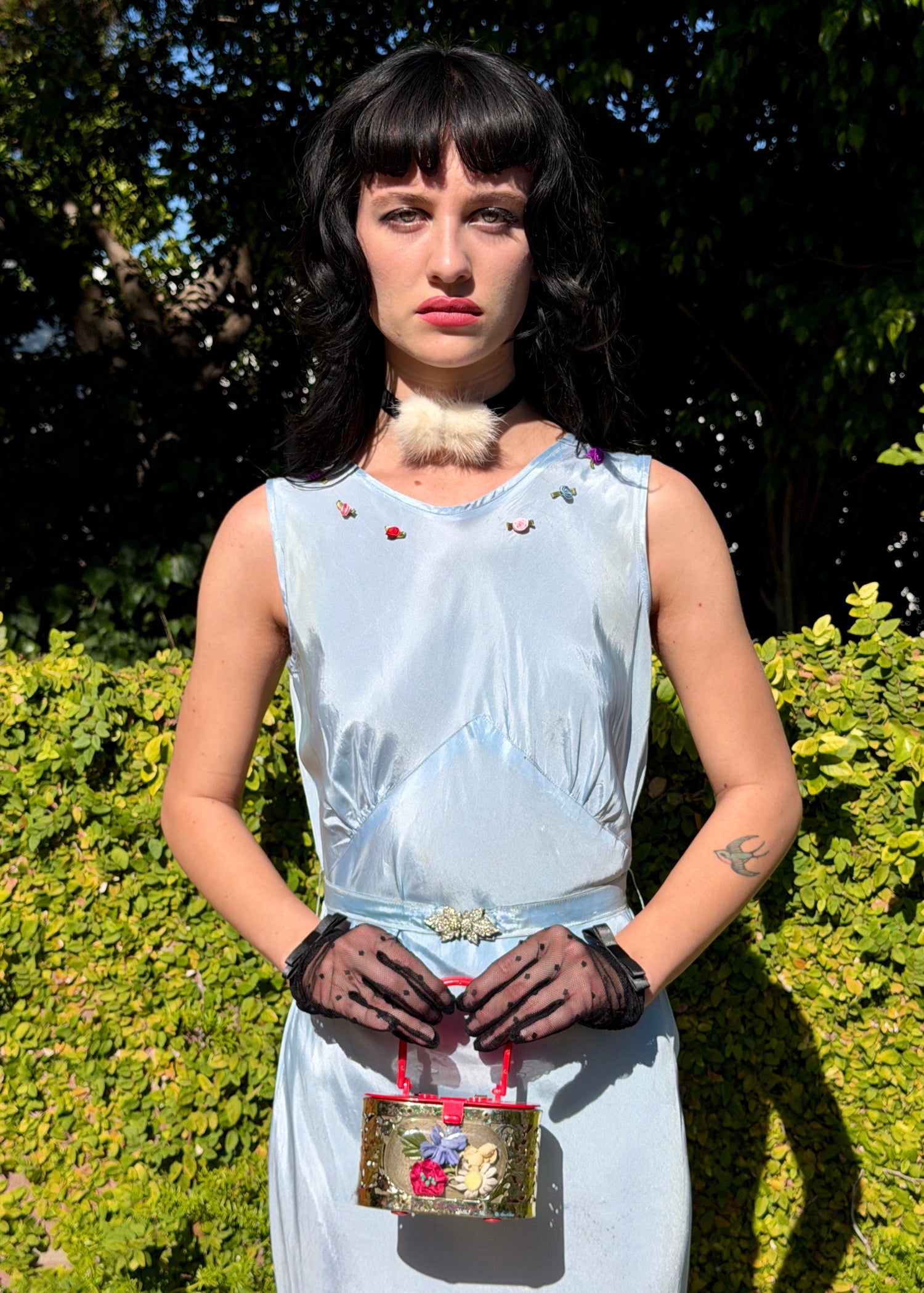 Woman wears antique 1930's silk taffeta gown in ice blue with tiered ruffle mermaid skirt hemline and removeable art deco belt