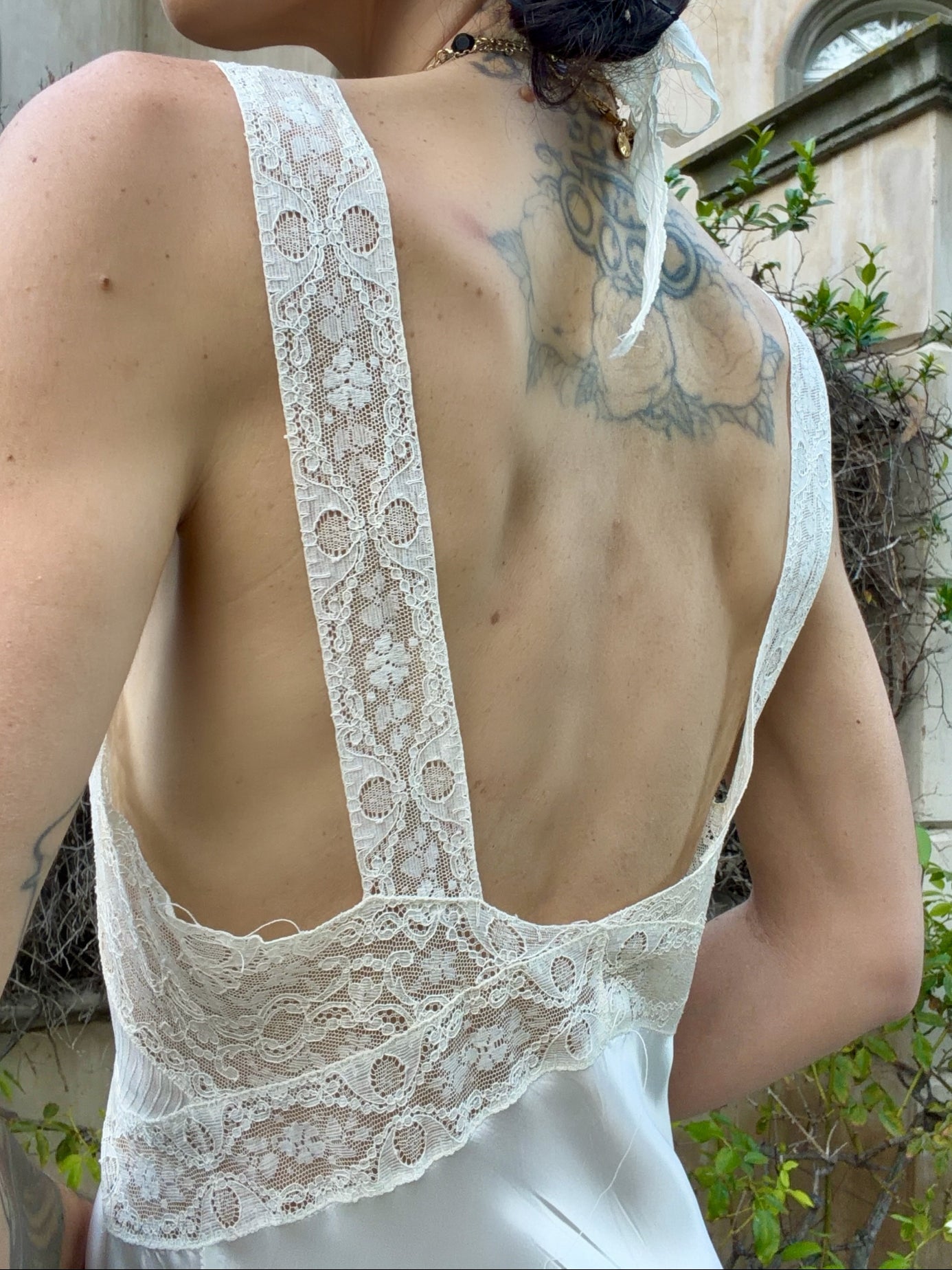 woman wearing antique 1930's silk slip gown in bone white with ivory lace and bias cut skirt