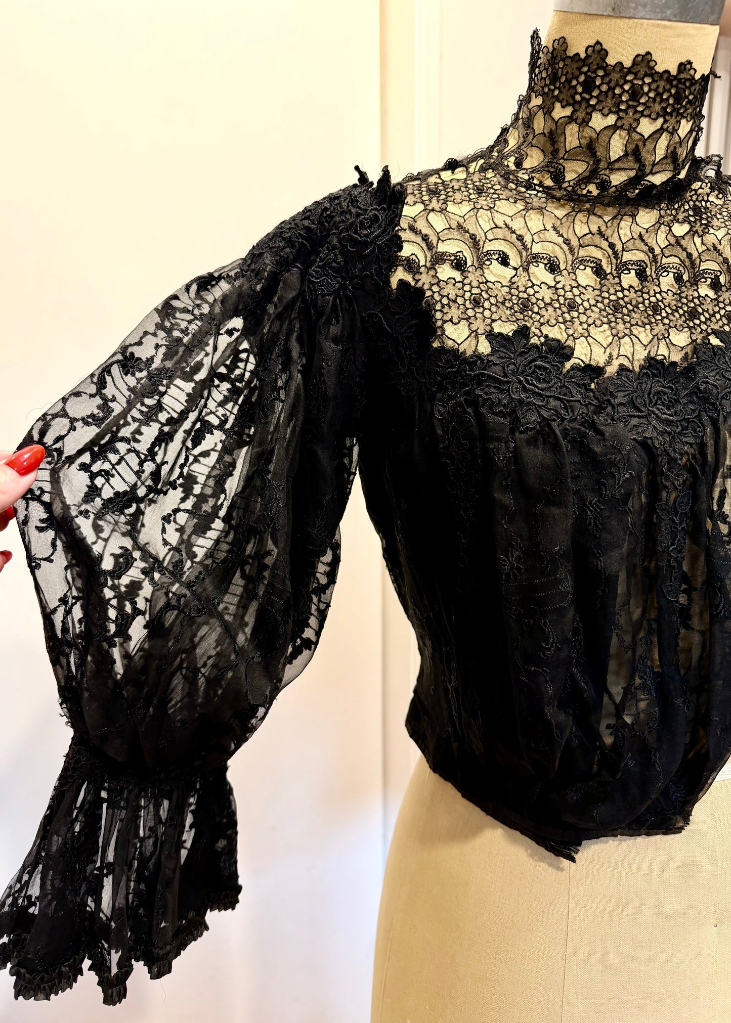 1890's Victorian mourning corset Black lace garment on a mannequin with a plain background