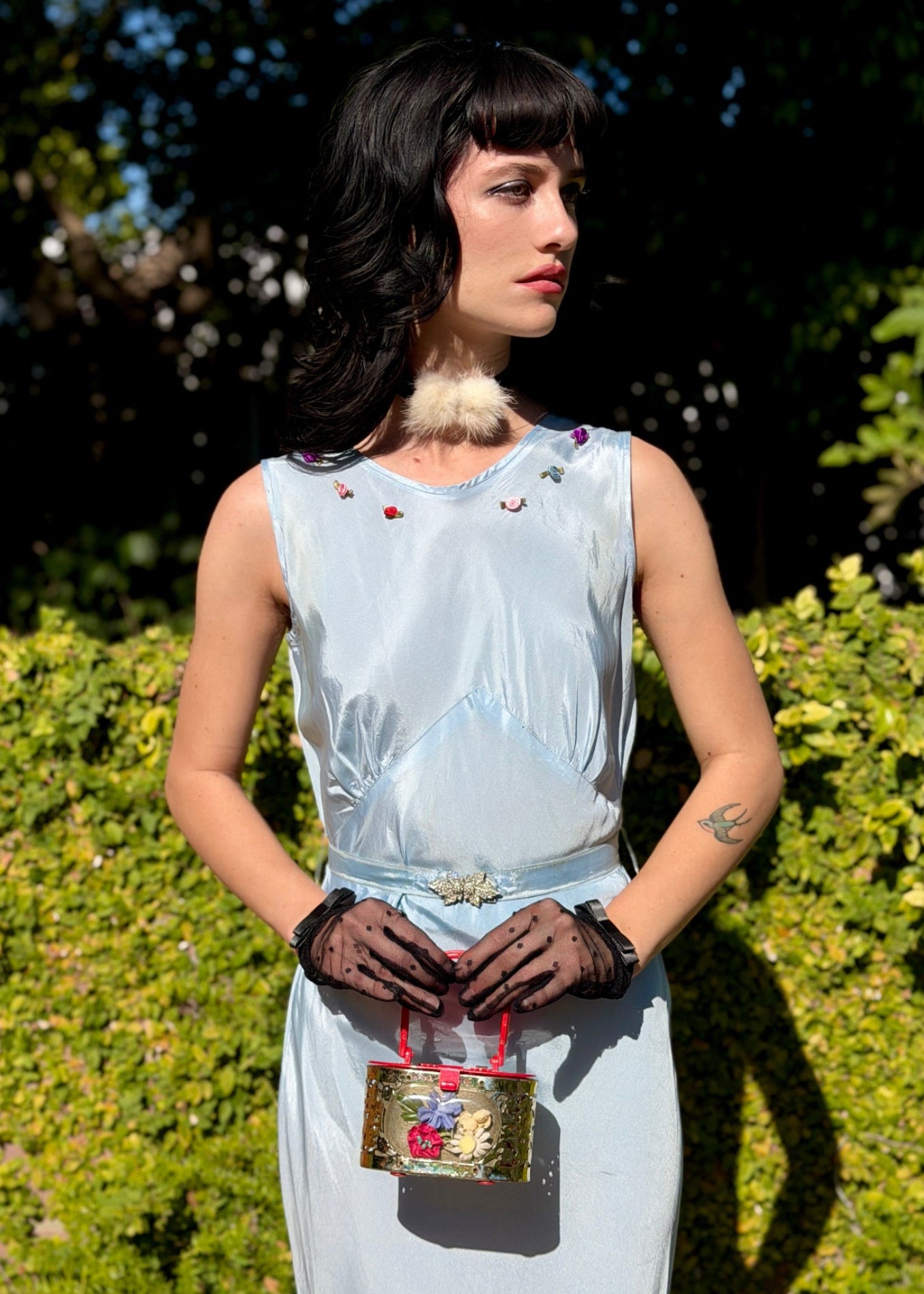 Woman wears antique 1930's silk taffeta gown in ice blue with tiered ruffle mermaid skirt hemline and removeable art deco belt