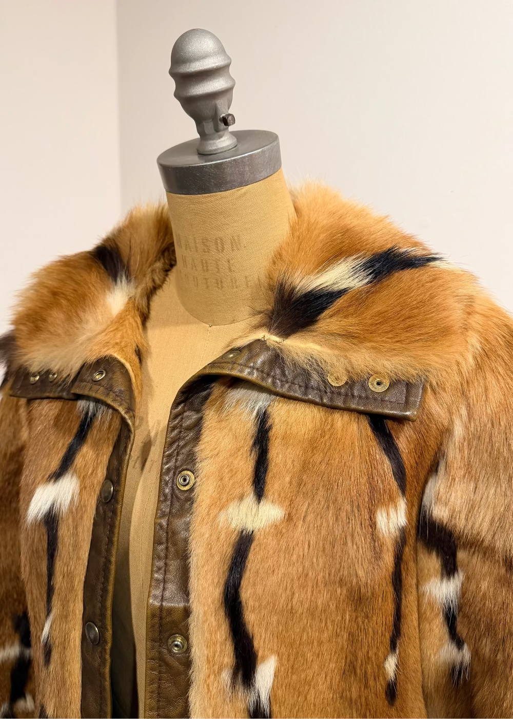 Brown fur coat on a mannequin with a plain background