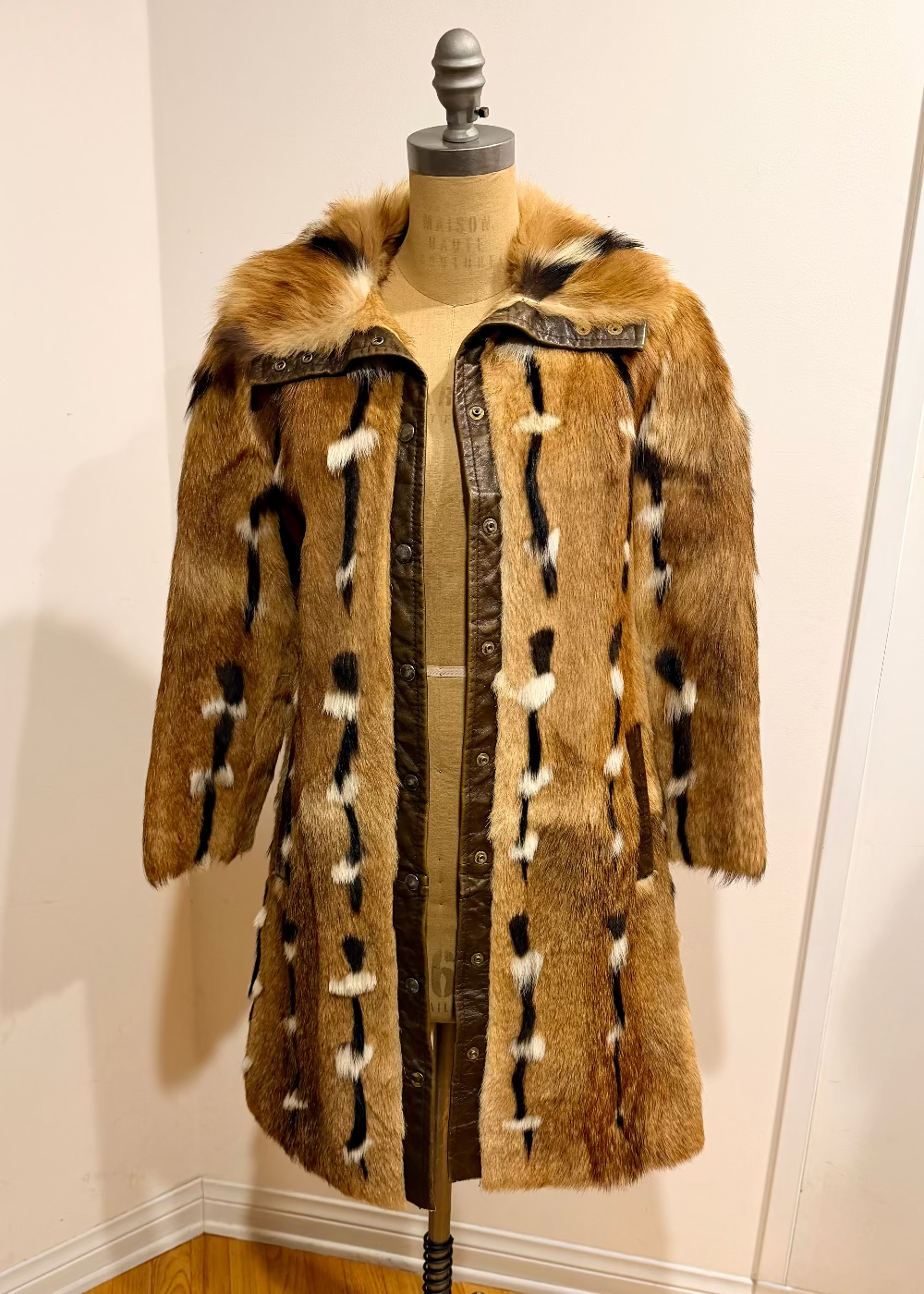Fur coat on a mannequin against a white wall