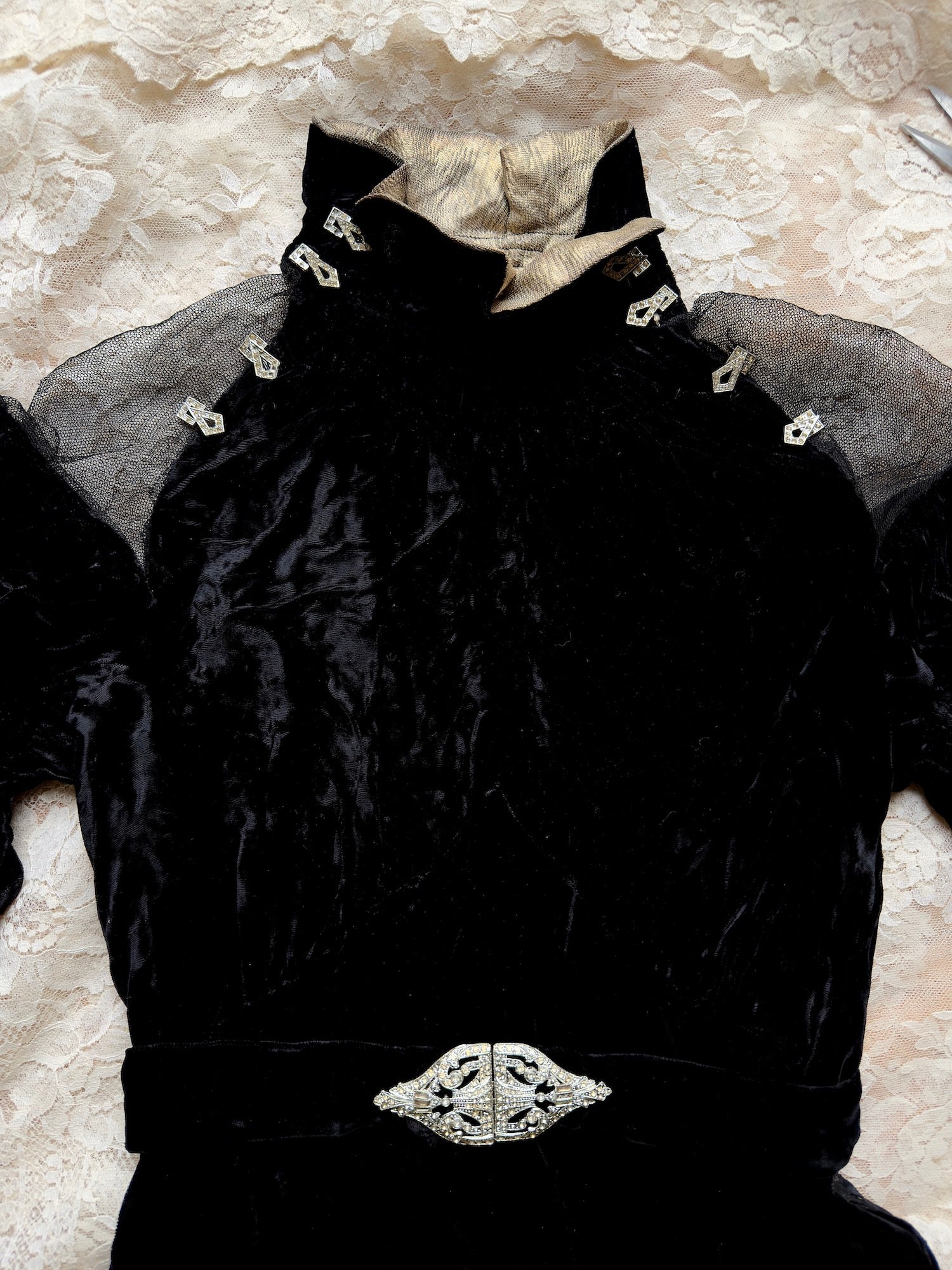 Woman wears antique 1930's black silk velvet Art Deco evening gown in field