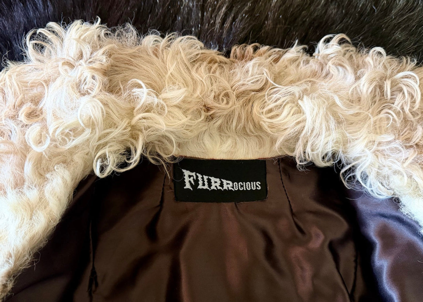 Close-up of a brown garment with fluffy white trim and a 'Furracious' label.