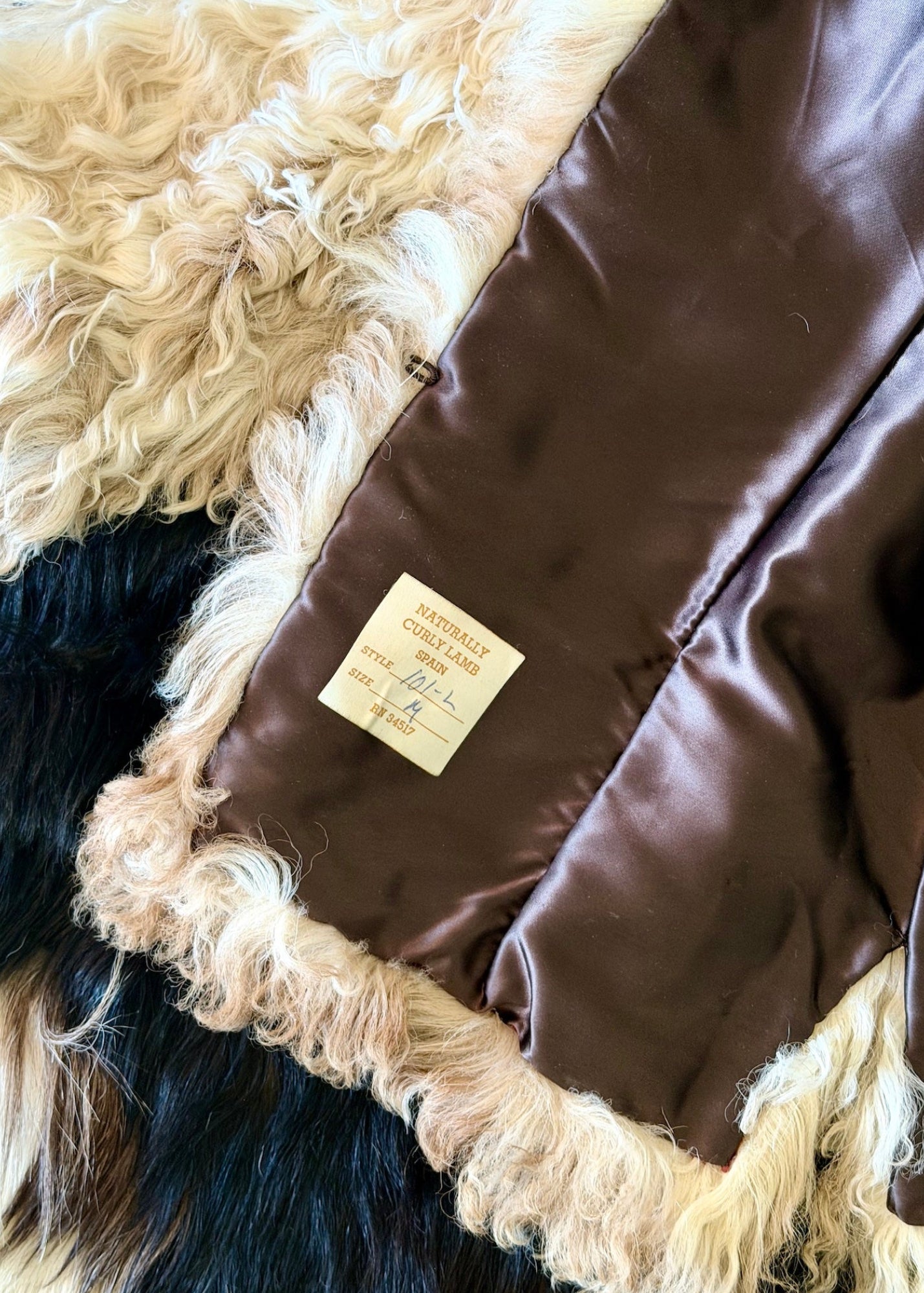 Brown leather jacket with fur trim on a textured surface